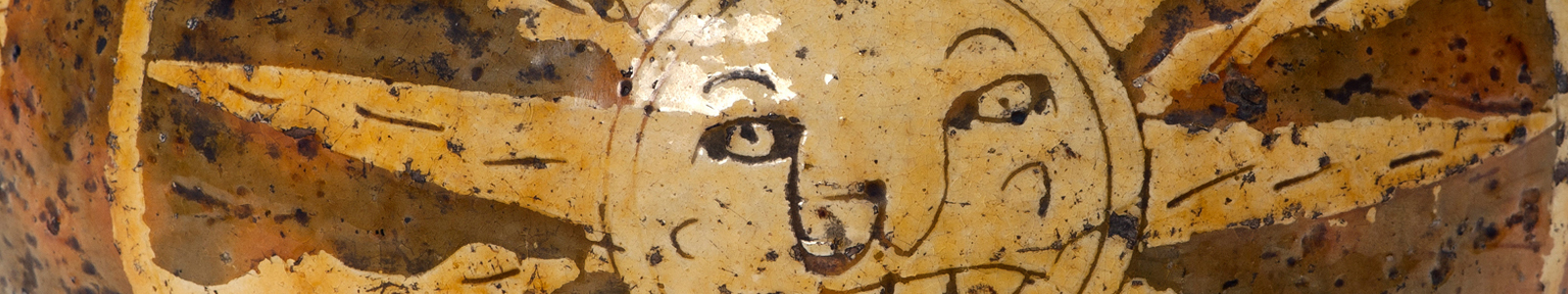 Close up of face on a sun from a harvest jug in the MERL collections