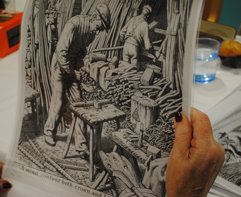 A hand holding an illustration of a man making a rake, for The MERL Cultural Commissioning project.