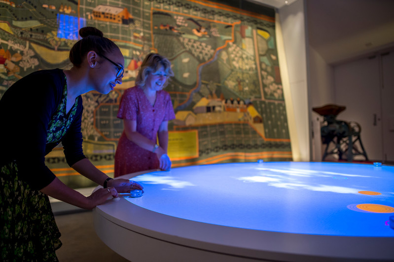 2 people playing the digital interactive game in the Our Country Lives gallery at The MERL