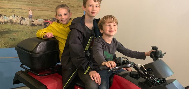 Children sitting on the quad bike at the MERL for the Virtual Reality experience