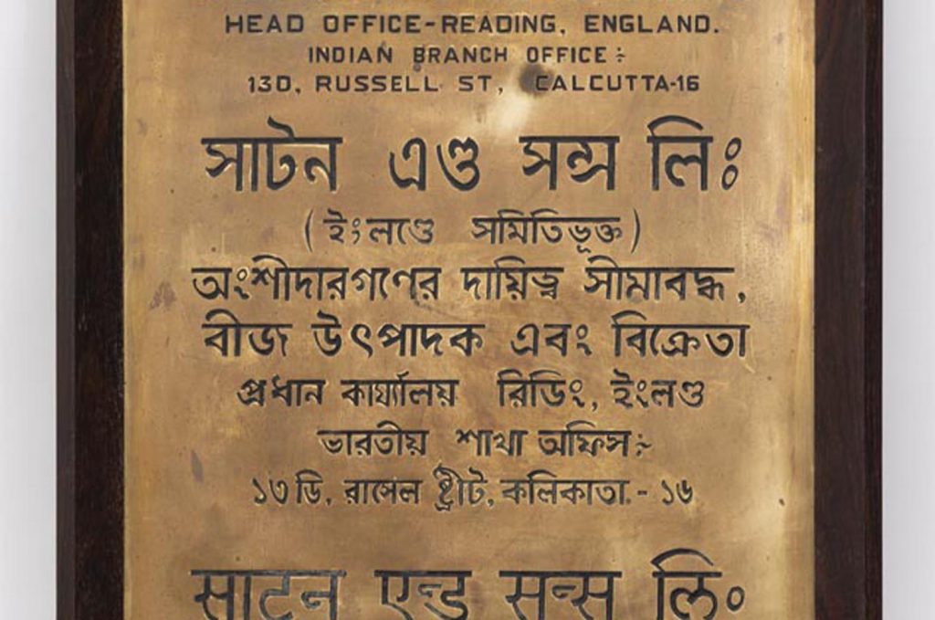 A brass plaque with text in different scripts