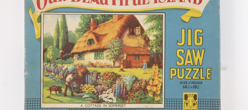 Jigsaw puzzle box featuring country cottage (MERL 2012/283/1-4)