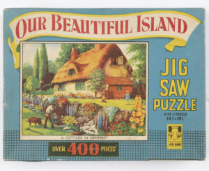 Jigsaw puzzle box featuring country cottage (MERL 2012/283/1-4)