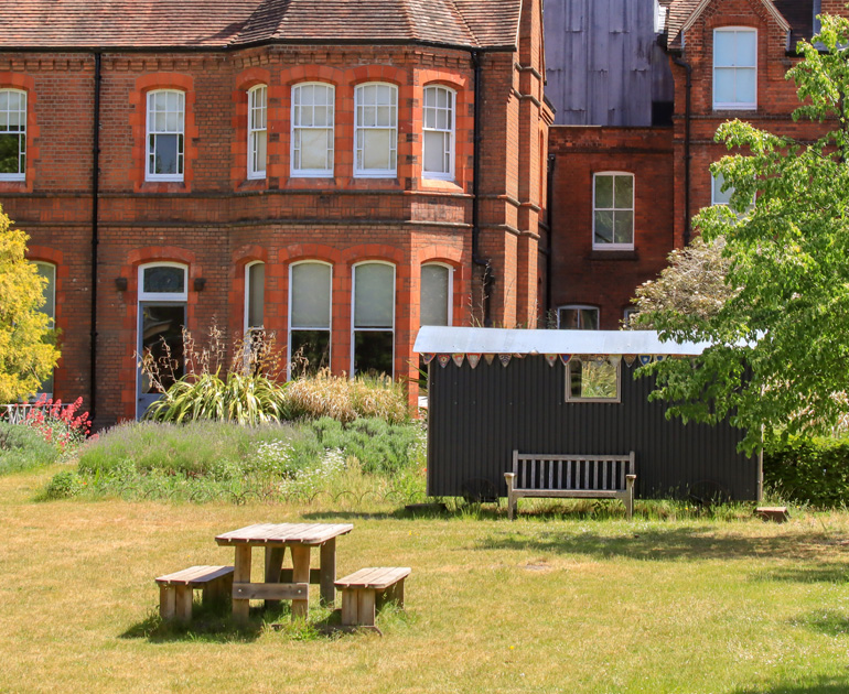 Picnic bench and shepherds hut in The MERL garden