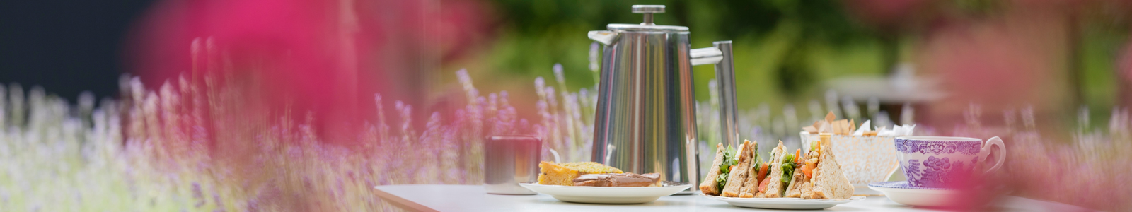 Table in the MERL garden with coffee pot, sandwich and cake