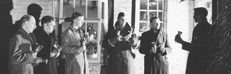 Carolers ring handbells at Christmas.
