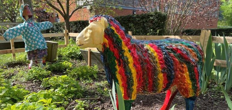 Sheep and scarecrow in the model farm in the herb garden