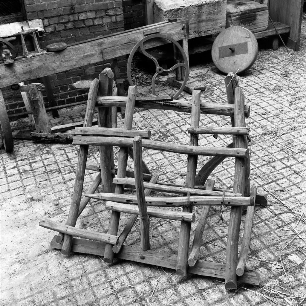 This brake was used by a hurdlemaker when making wooden gate hurdles. It consists of a complex wooden frame supporting a toothed iron jaw. It was acquired from the 1951 Festival of Britain. Hurdle maker's brake (MERL 52/36)
