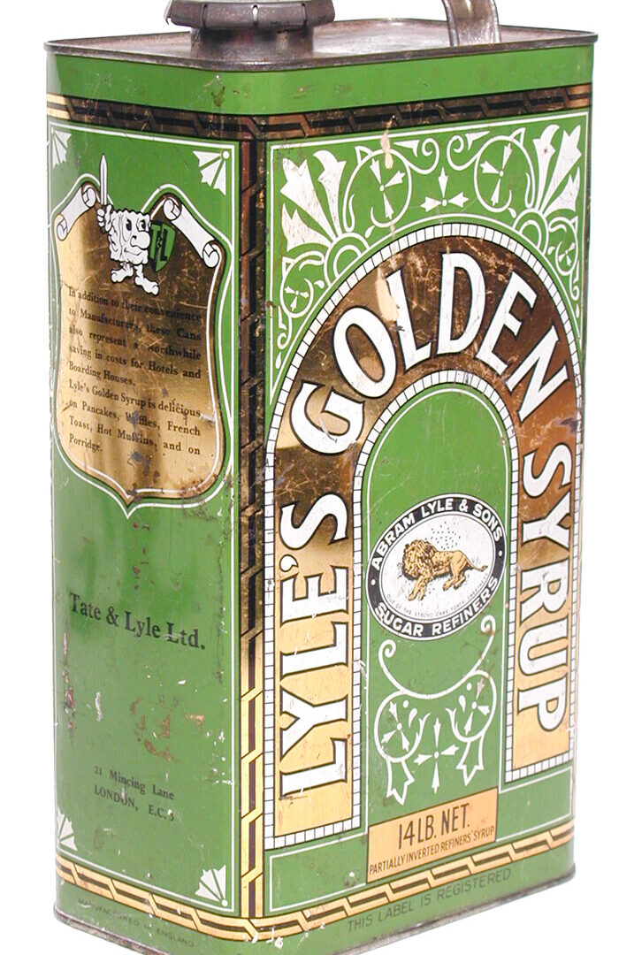 Can, Golden Syrup (object name) This is a Lyle's golden syrup can with handle and clip lid, made of metal with a design in gold, green and white. It is made to hold 14 lbs of syrup.
