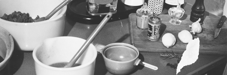 A black and white photograph of a person cooking.