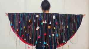 Model wearing a cape that is part of the Sew What exhibition