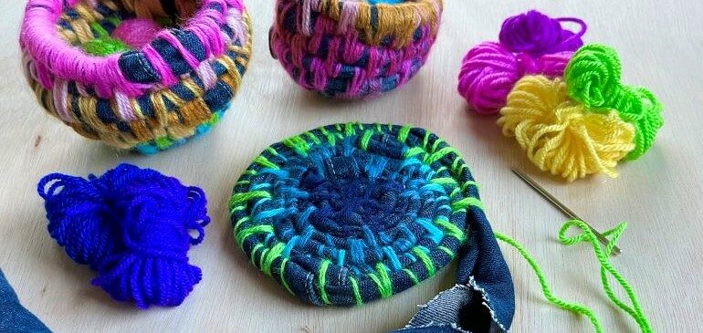 Fabric and wool laid out on a table next to fabric coil pots