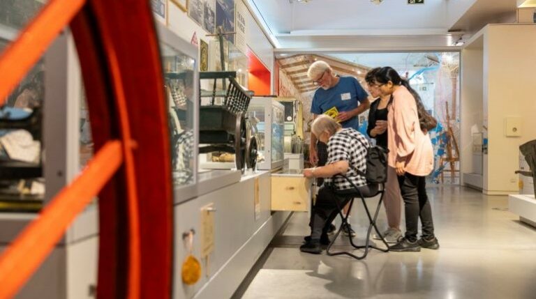Visitors and volunteers looking in the archive drawers in the MERL galleries