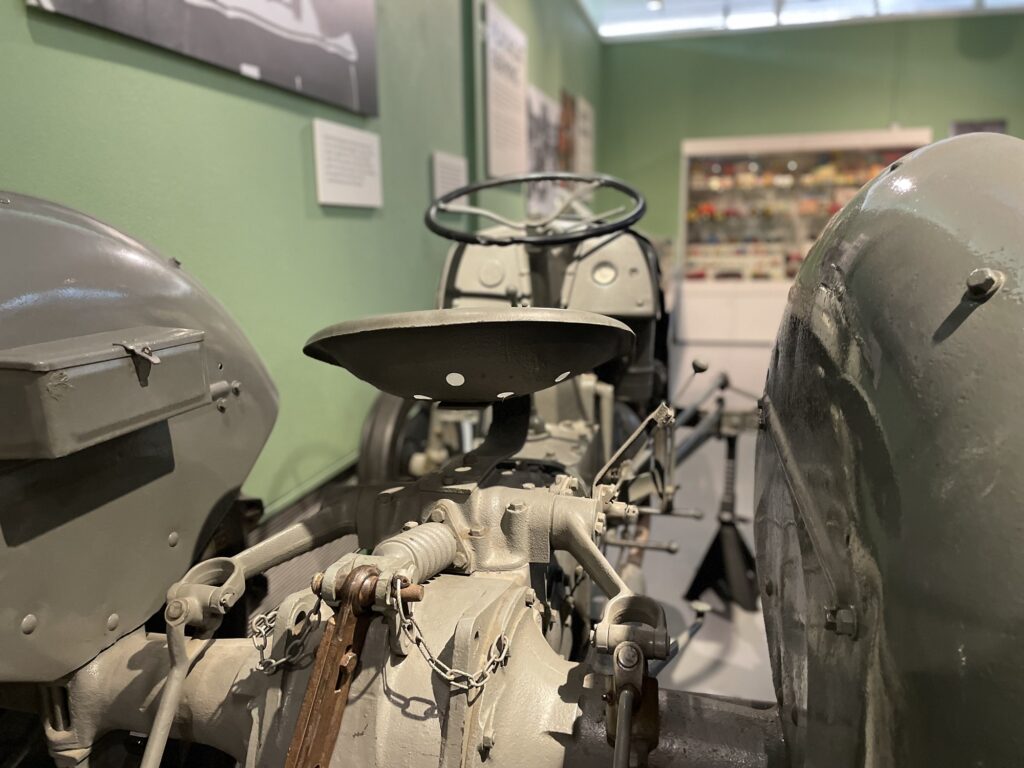 Detail of a TE20 Ferguson tractor with displays of farm toys and models in the background