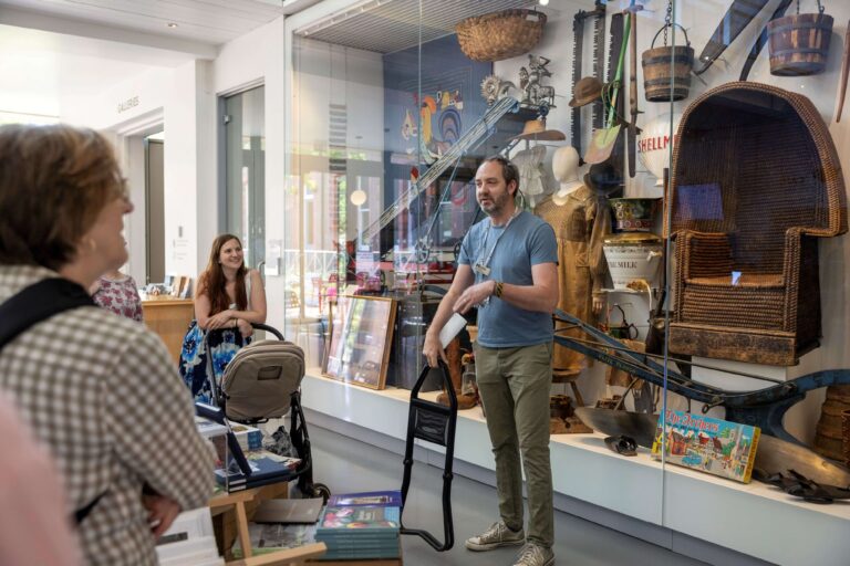 MERL Curator Ollie Douglas standing in front of the Welcome Case at The MERL