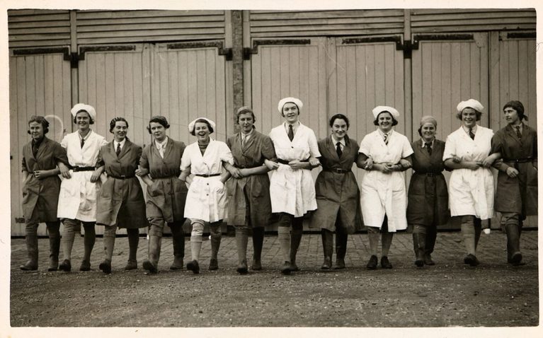 Row of 12 women marching together, employees at The National Institute in Dairying in the early-mid 20th