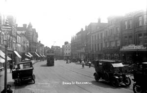 A photograph of a street scene with early twentieth century cars, from the Dann Lewis collection.