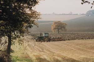 An image of a tractor in a field, part of the Peter Adams Collection.