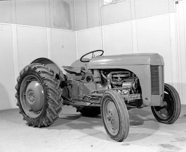 A black and white photograph of a Ferguson tractor sitting in the old museum galleries on Whiteknights campus, University of Reading.