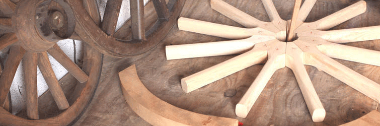 An unfinished wagon wheel lies on a table.