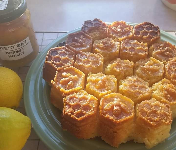 A Devonshire Honey Cake moulded into hexagons, with honey and lemons on the side