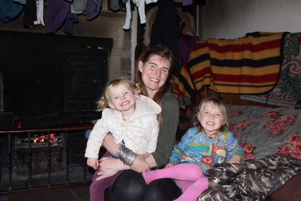 The Yorkshire Shepherdess Amanda Owen sitting in front of her hearth with two young daughters on her lap