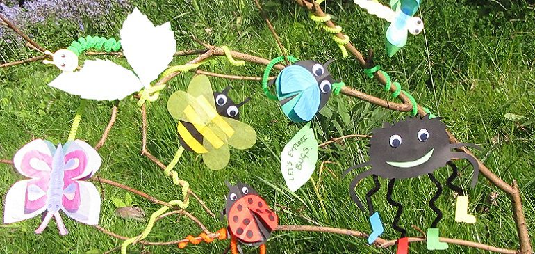Bug craft made from brightly coloured card tied to a branch in the MERL garden