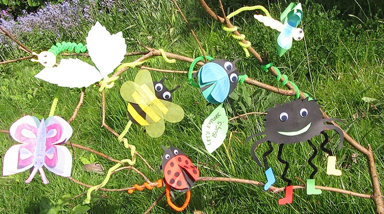 Bug craft made from brightly coloured card tied to a branch in the MERL garden