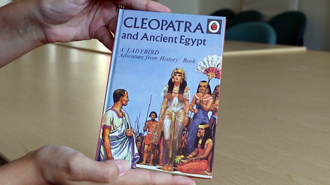Two hands holding the Ladybird Book of Cleopatra, with an illustration of the Egyptian Pharaoh on the cover