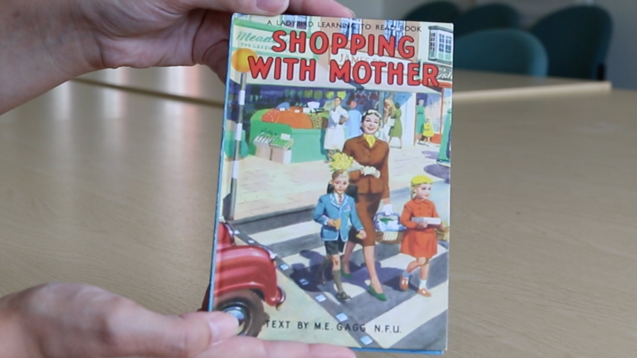 Two hands holding the Ladybird book Shopping with Mother