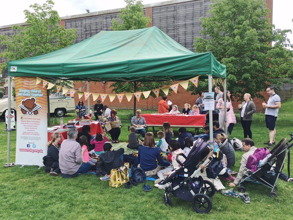 A picture of people under a green gazebo in the garden listening to stories