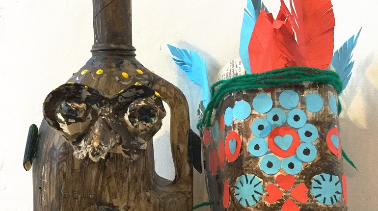 A Melanesian mask (blue and red) and a grumpy medieval face jug made out of recycled materials.