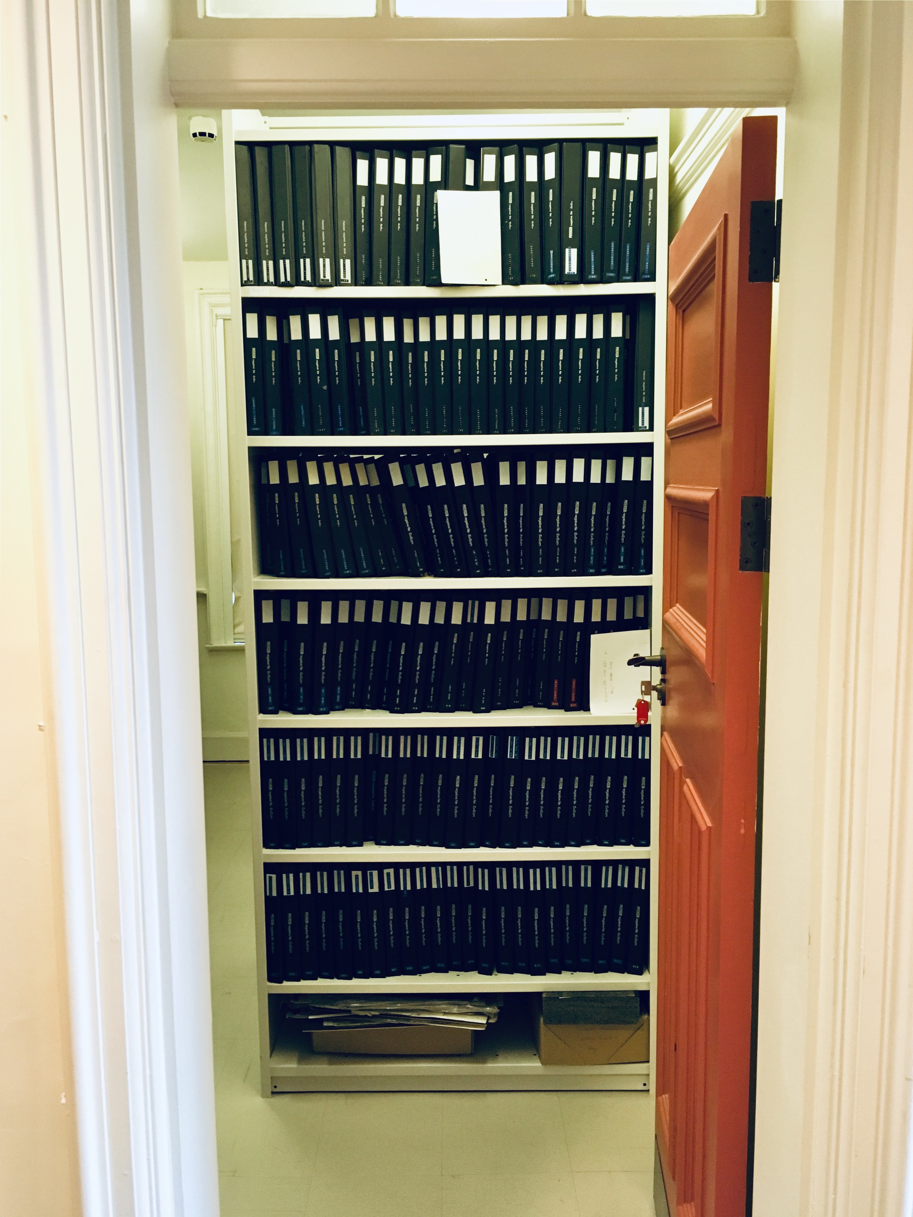 Image of an open doorway looking onto a shelf full of ring-binders.