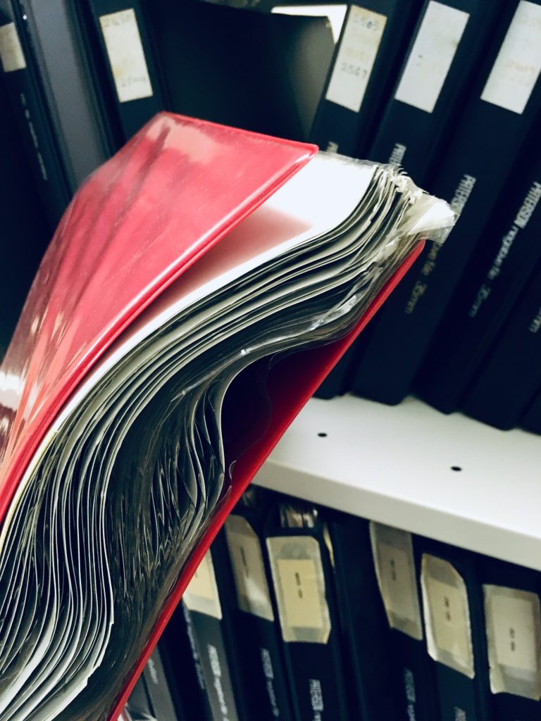 Close-up photo of photographic negatives and prints twisted in an old ring-binder