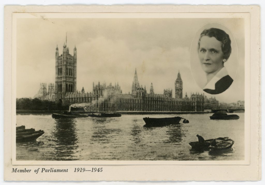 A black and white postcard featuring boats on the Thames in from of the Houses of Parliament with a cut out of a portrait of Nancy Astor in the top right hand corner
