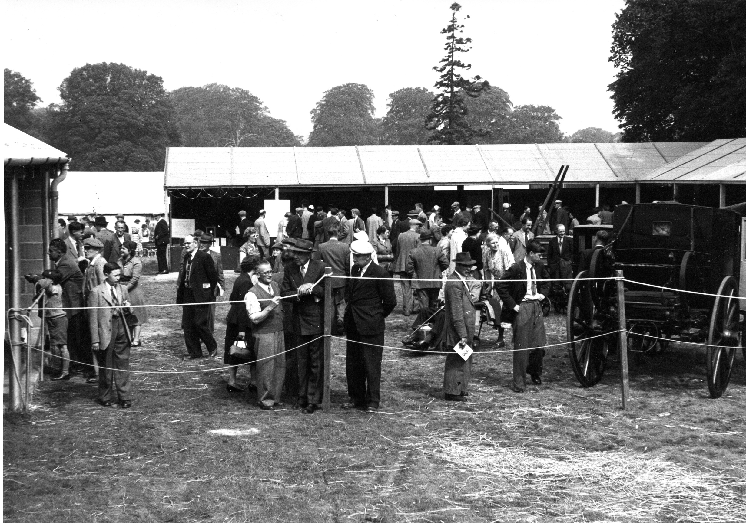 The Museum of English Life Stand at the Royal Agricultural Show, Nottingham, 1955, which was a reconstruction of the first Royal Agricultural Show held in Oxford in 1839. This black and white image shows people looking at old machinery and equipment on the Museum's a trade stand