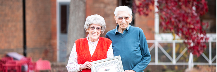 Jan and Ron Butler with their distinguished volunteer award in the garden at the MERL