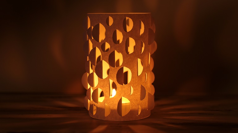 Paper lantern glowing orange light and shadows on a dark background