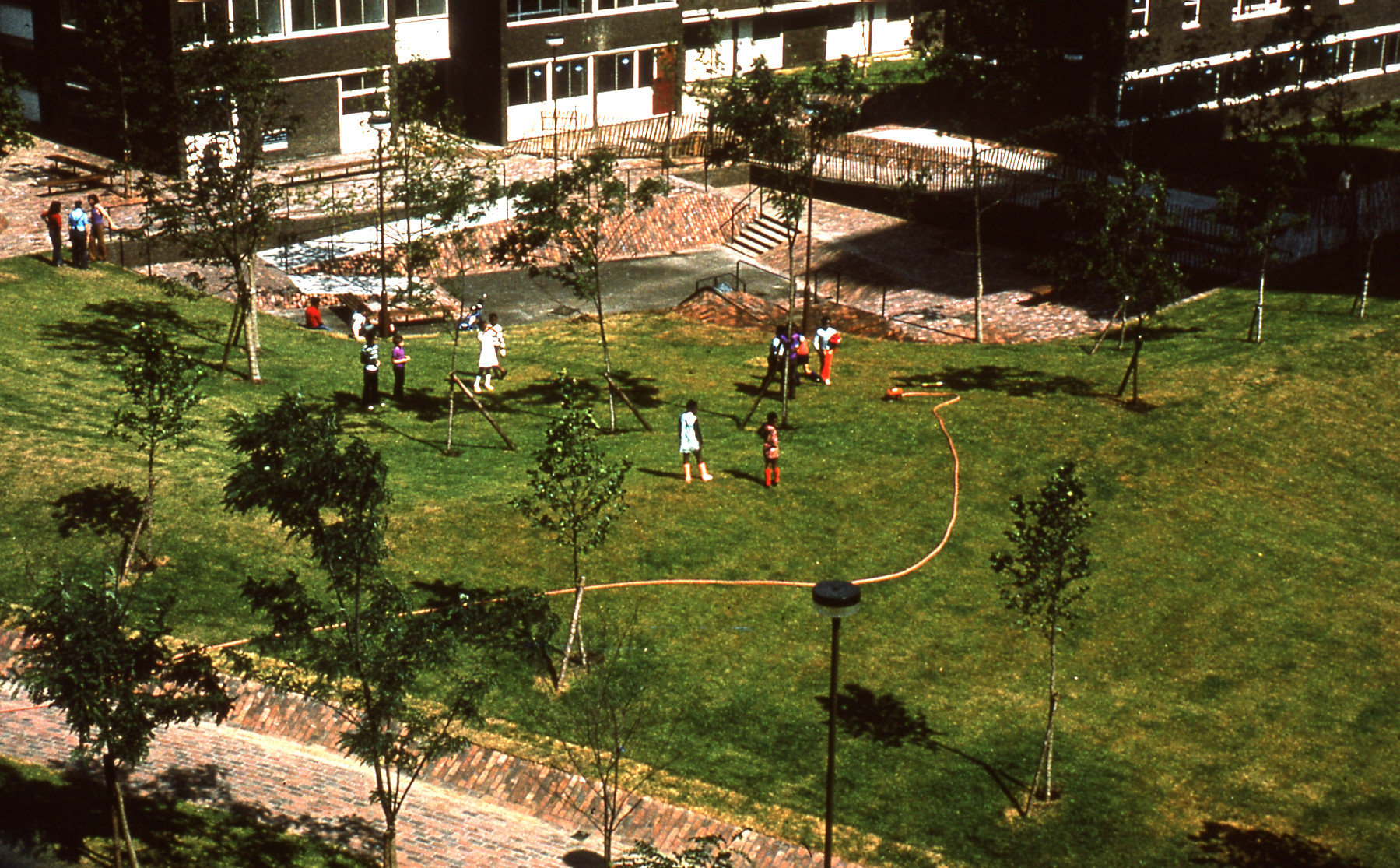 Photograph of children playing on a grassy area at the Brunel Estate in around 1974