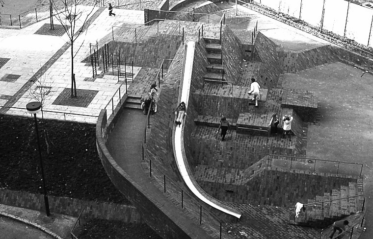 Aerial view of children playing on the multi-level brick surfaces and slide at the Brunel Estate play area