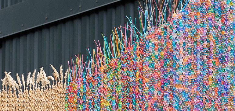 Close up of a Maria McKinney sculpture made from colourful semen straws and straw