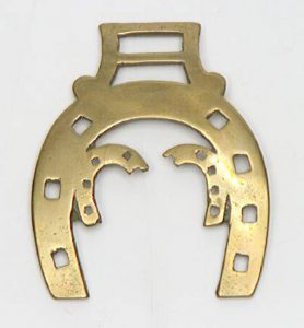 Horse brass in the shape of a horse shoe
