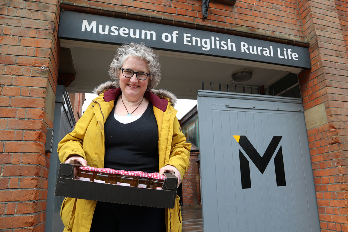The Jam Lady standing in front of the MERL entrance delivery a box of jars of mint jelly