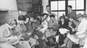 Black and white photo of women holding chickens