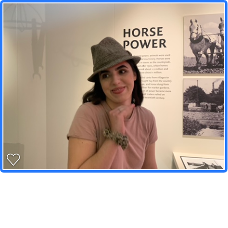 Student wearing one of the MERL dress-up hats in front of the 'horse power' display