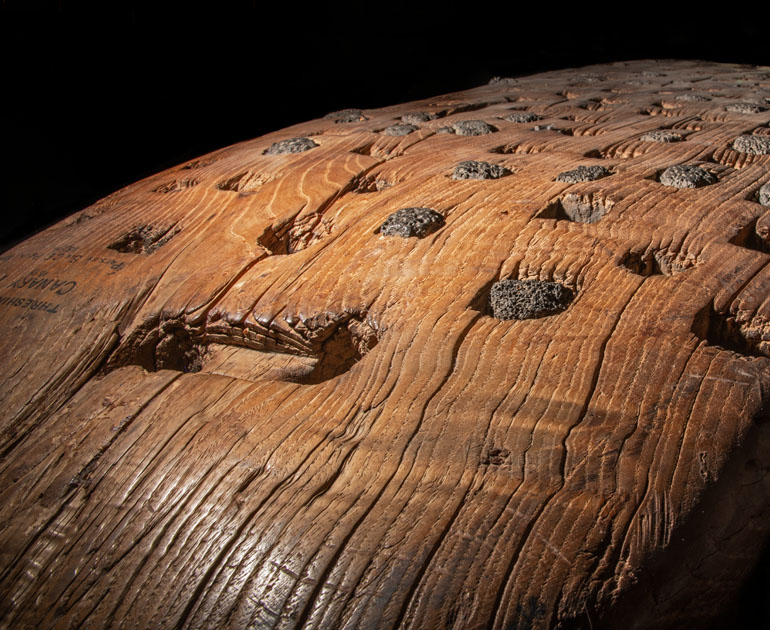 Detail of wooden threshing sled with lava teeth inserted in surface