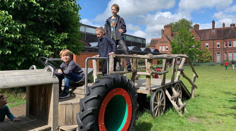 Children playing on the tractor in the MERL garden for innovations science workshop