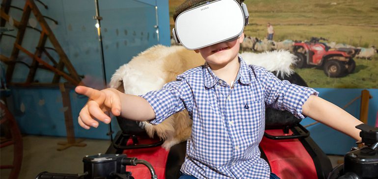 Boy on the MERL quad bike wearing a virtual reality headset