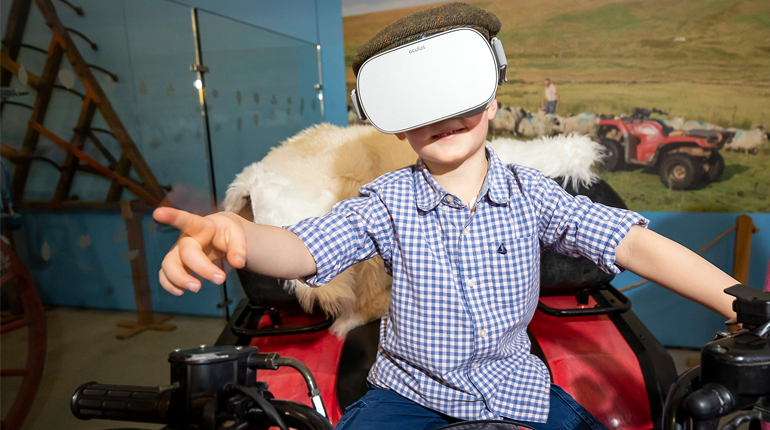 Boy on the MERL quad bike wearing a virtual reality headset