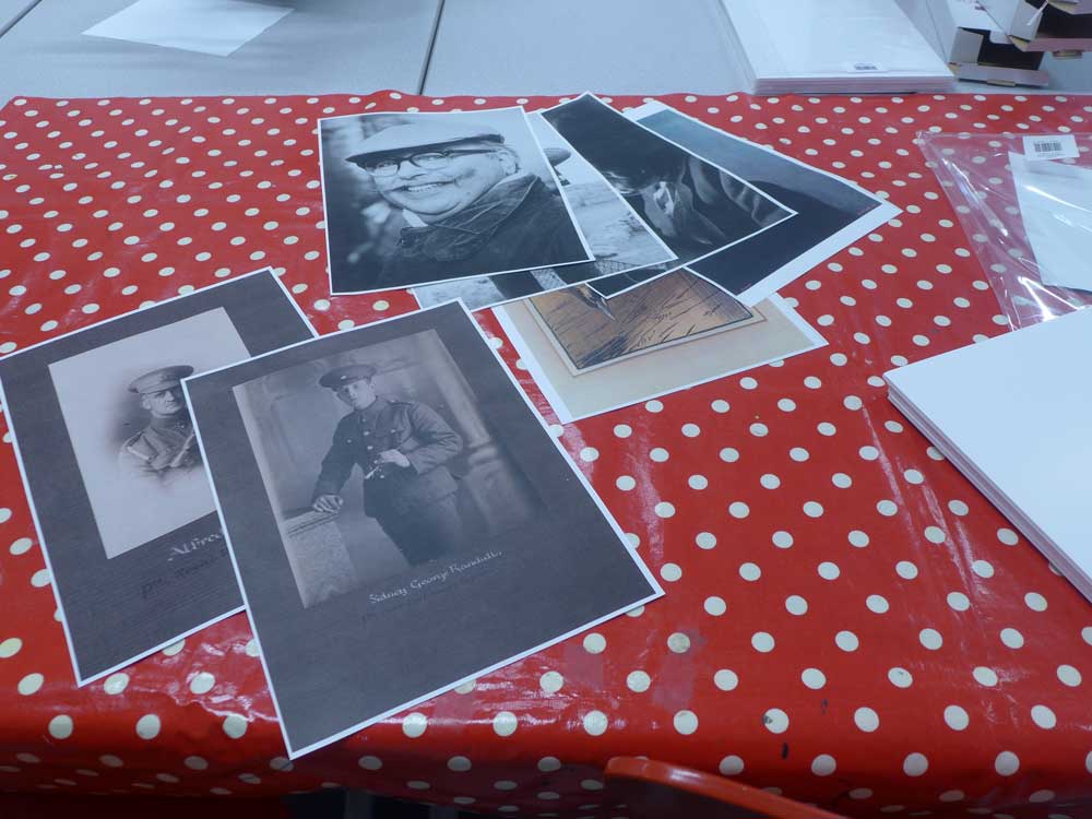 Copies of black and white archive pictures on a table with a red and white spotted tablecloth